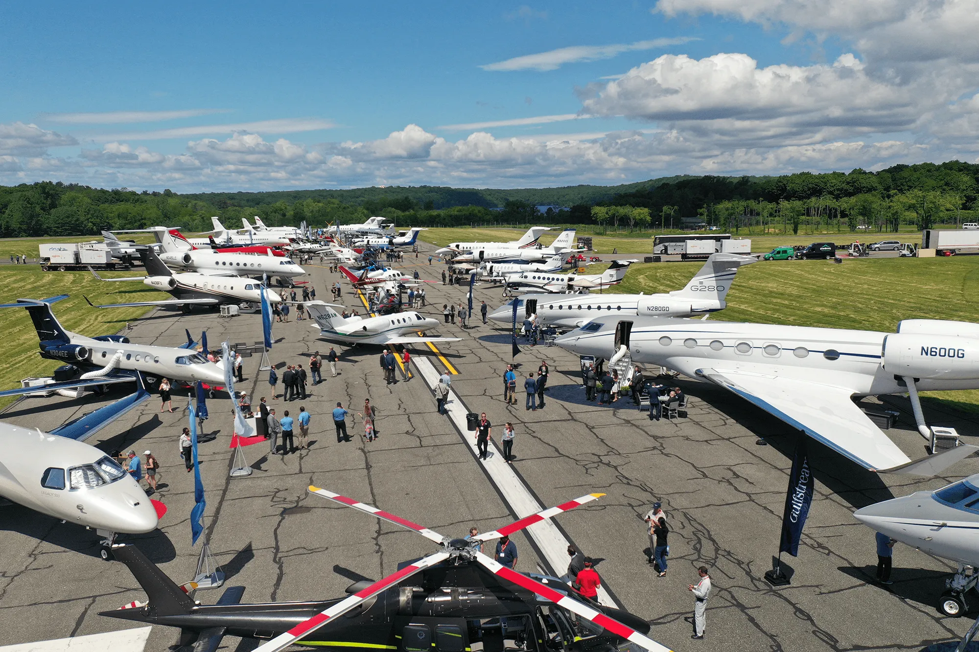 Private jets, helicopters, and guests gather on the tarmac at a Westchester County Airport (HPN) aviation event.